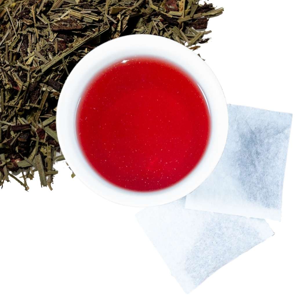 Brewed hibiscus lemongrass leaf herbal tea with two tea bags and loose contents of tea bags in upper left hand corner